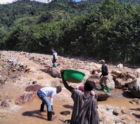 Locals survey the damage after mudslides in DRC